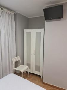 奥维多菲达尔戈旅馆的卧室配有白色的床和椅子