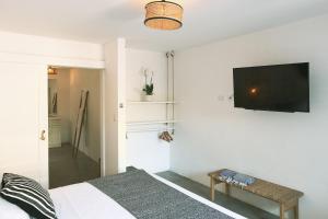 诺萨拉La Negra Surf Hotel的卧室配有一张床和壁挂式平面电视。