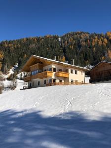 布拉伊埃斯Apartments Oberhollenzer的雪覆盖的山顶上的房子