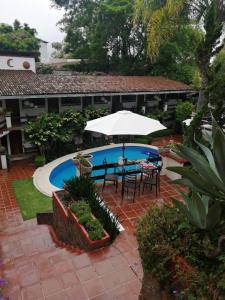 巴耶德布拉沃Casa Dalinda的一个带桌子和遮阳伞的庭院和一个游泳池