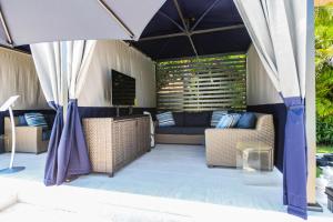 霍姆斯海滩Anna Maria Beach Resort的帐篷下设有带沙发和椅子的天井。