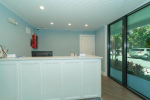霍姆斯海滩Anna Maria Beach Resort的一间厨房,配有白色的橱柜和大窗户