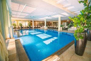 利恩茨Grandhotel Lienz Business-Wellness & Gourmet的酒店大堂的大型蓝色泳池