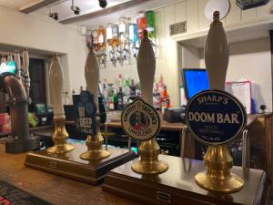 达文特里The Plough Inn Boddington的吧台上装有三瓶玻璃瓶的酒吧