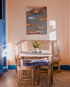 布拉干萨Pousada Aruans Casarão的餐桌和椅子,墙上有绘画作品