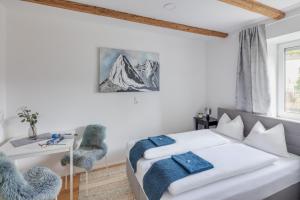 因斯布鲁克Innsbruck City Chalet的白色的卧室设有床、书桌和窗户