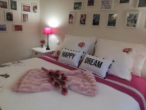 波尔图Architect House的一张带粉色毯子和幸福梦幻枕头的床