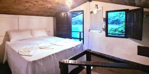 卡拉伊瓦Casa do Mar Caraíva的客房设有一张带桌子和窗户的床。