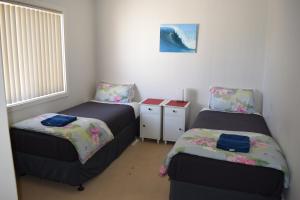 Port Noarlunga克里斯蒂斯海马假日联排别墅的一间卧室设有两张床和窗户。