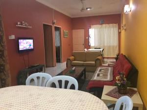 Kota SamarahanDesa Ilmu Homestay的客厅配有沙发和桌椅