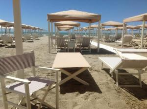 维亚雷焦Beach House,Giardino,Piscina,Spiaggia, 6 posti的海滩上摆放着桌椅和遮阳伞