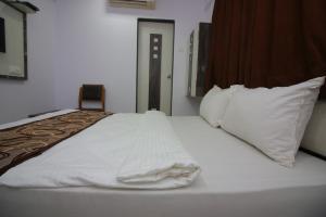 纳威孟买阿帕克斯酒店的一张带白色床单和枕头的床
