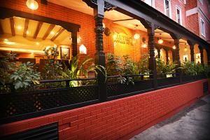 加德满都Kumari Boutique Hotel的一间有砖砌建筑的餐厅,上面有植物
