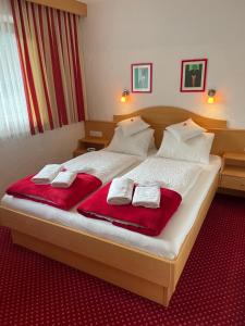 洛伊塔施W2 Haus Ganghofer的一间卧室配有一张大床,上面有红色的毛巾