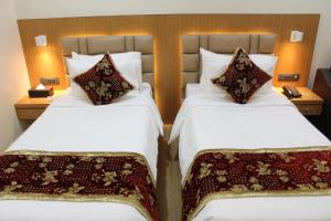 古尔伯加S R Continental的配有2张床铺的酒店客房,提供白色床单和枕头