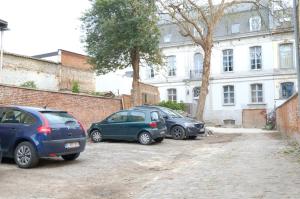 蒙斯La Maison de la Duchesse de la Vallière - Parking privé gratuit的三辆车停在大楼前的停车场