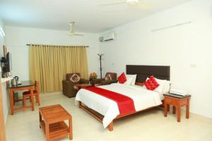 KondottiKTDC Tamarind的卧室配有一张白色的大床和一张沙发。