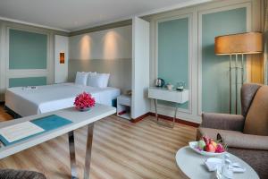 胡志明市温莎广场酒店的酒店客房配有一张床铺和一张桌子。