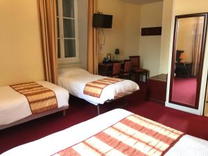 SancoinsLogis hotel Saint-Joseph的酒店客房,设有两张床和镜子