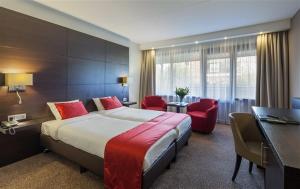 莱茵河畔阿尔芬凡德瓦克酒店的酒店客房带大床和红色椅子