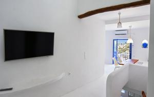 伊利达The Blue and White house in Ioulis, Kea的一间客厅,在白色的墙上配有电视
