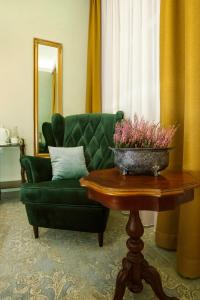 比亚韦斯托克Kamienica Boutique ApartHotel的客厅配有绿色沙发和桌子