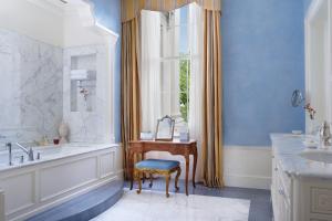 伦敦The Lanesborough, Oetker Collection的带浴缸、水槽和窗户的浴室