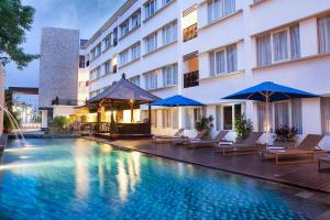 库塔库塔纳特雅酒店的酒店设有带椅子和遮阳伞的游泳池