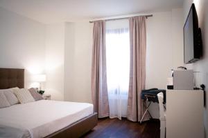 佛罗伦萨SIGNORIA '64的一间卧室配有一张床、一张书桌和一个窗户。