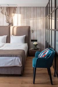 利沃夫Loft7的一间卧室配有一张床和一张蓝色椅子
