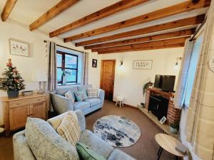 惠特比Grosmont Cottage, Ruswarp的客厅配有两张沙发和一台电视机