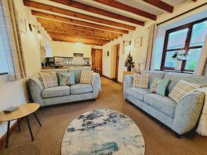 惠特比Grosmont Cottage, Ruswarp的客厅配有两张沙发和一张桌子