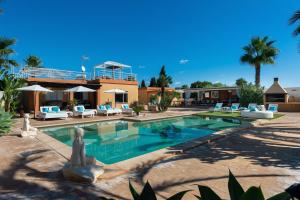 伊维萨镇Serena Villa的一座房子前面带雕像的游泳池
