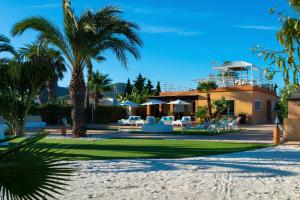 伊维萨镇Serena Villa的棕榈树海滩上的房子