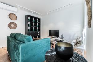 里斯本Casas da Tapada的客厅配有蓝色的沙发和电视