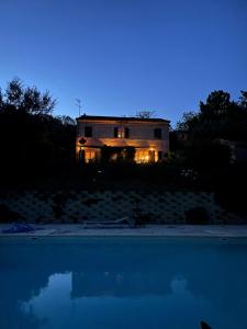 Monte GibertoCasa Raffaela, Charming villa with a nice pool的夜晚的房子,前面有一个游泳池