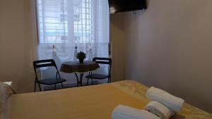 巴里CconfortHotels R&B Dolci Risvegli - SELF CHECK IN的客房设有桌椅、桌子和窗户。