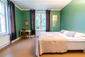 沃卡蒂Haapala Brewery restaurant and accommodation的一间卧室配有一张带绿色墙壁的床和一张桌子