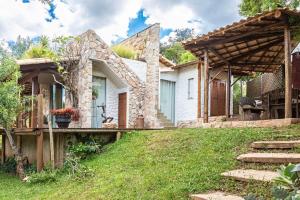 圣安娜杜里亚舒Sitio Jatoba/Lapinha da Serra的石头房子,设有花园和露台