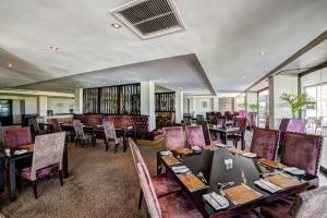 Phokeng皇家马朗酒店的用餐室设有桌椅和窗户。