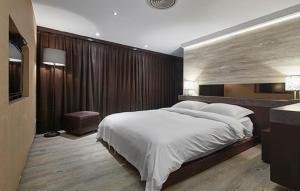 台北嘉宾阁温泉会馆的一间卧室配有一张大床和电视