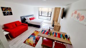 波哥大Toscana LOFT - Apartasuites的客厅配有红色沙发和红色椅子