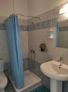 克里皮吉Hotel Ilios的浴室设有蓝色的浴帘和水槽
