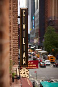 纽约CIVILIAN Hotel的城市街道上一座带时钟的建筑上的标志
