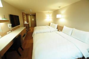 高雄康桥商旅-高雄站前馆的酒店客房设有两张床和电视。