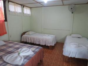Caño NegroPoponjoche Lodge Caño Negro的一间设有两张带白色床单的床的房间