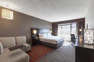 奥斯汀奥斯丁市中心假日酒店的酒店客房配有一张床、一张书桌和一张沙发。