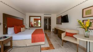 坎昆Grand Park Royal Cancun - All Inclusive的酒店客房设有一张大床和一张书桌。