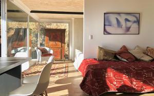 萨帕利亚尔Lofts Casa El Pangue Zapallar的卧室配有一张床和一张桌子及椅子