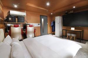 昌原市唐酒店 的一间卧室配有一张大床和一台平面电视